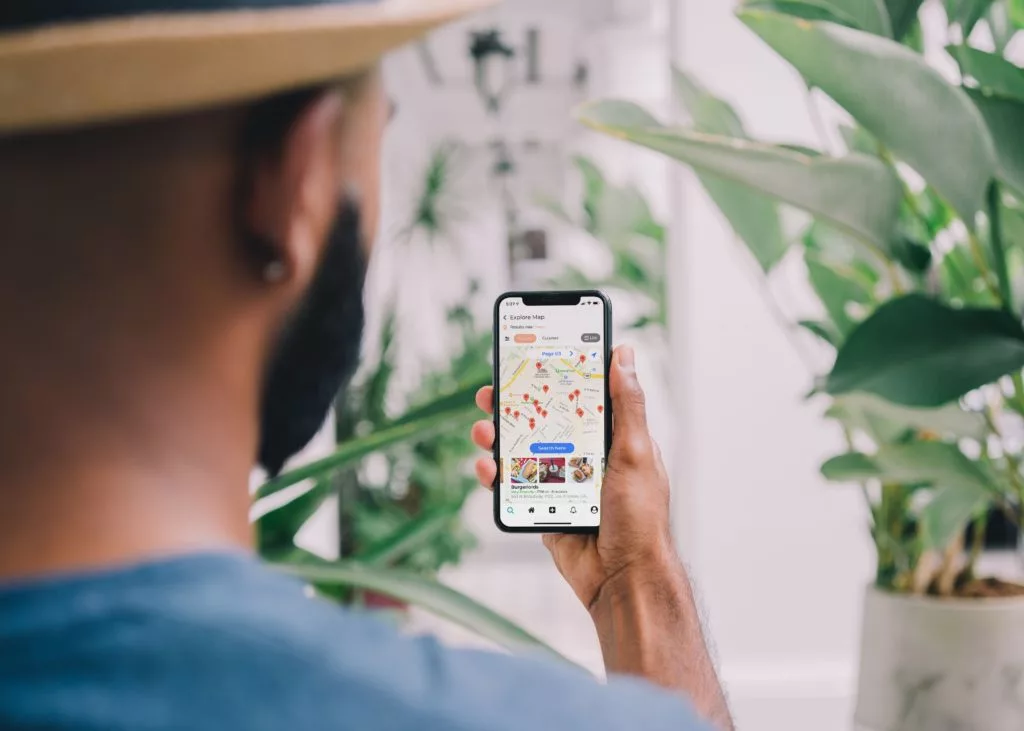 man looking at travel content (map with POIs) on his phone