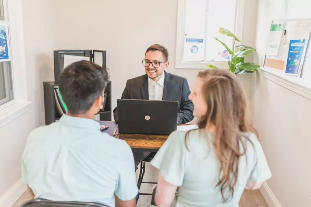 Couple talking to a sales agent at his office